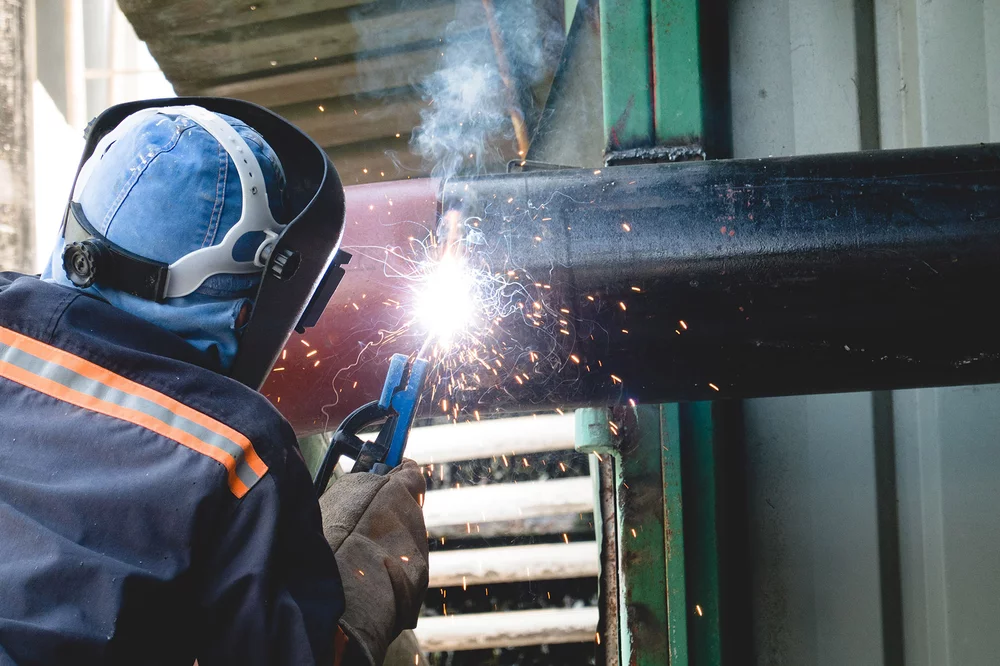 Abbildung eines Mannes bei Schweißarbeiten: Auch Sicherheitsvorschriften bei feuergefährlichen Arbeiten werden in Teil B der Brandschutzordnung definiert.